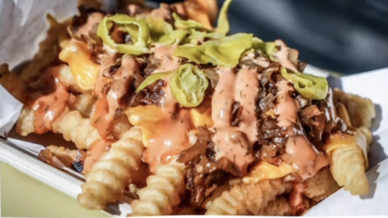 A tray of crinkle cut fries loaded with toppings