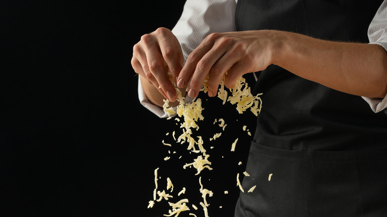 Chef using shredded cheese