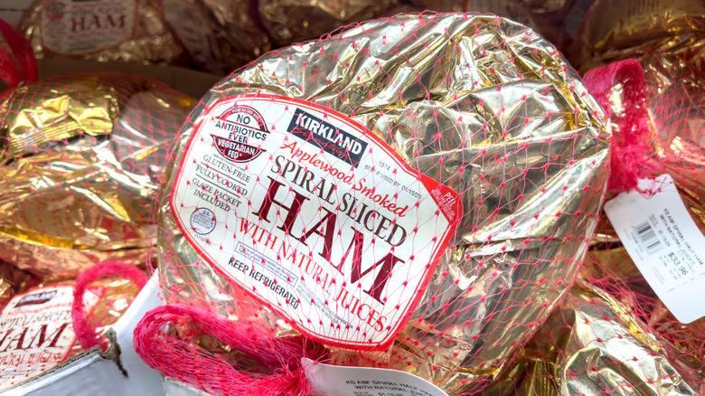 a view inside a fridge at Costco with gold-wrapped Kirkland Signature spiral-sliced hams