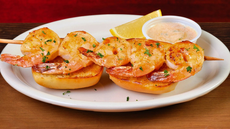 Texas Roadhouse sidekick of shrimp on top of toast on a white plate