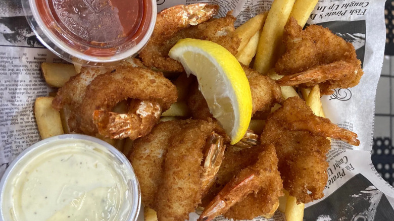 Fried Shrimp with lemon and sauces on newspaper
