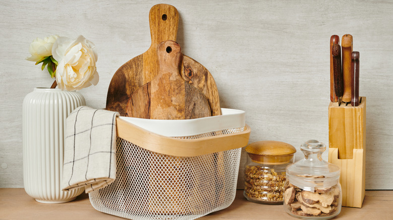 A pair of cutting boards are kept in a wire basket