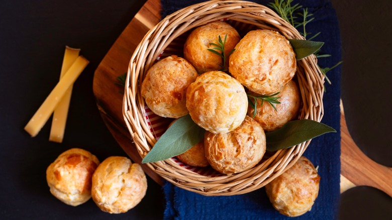 A basket of Gougères on a wooden board