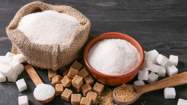 Bowls of sugar and sugar cubes on a dark table