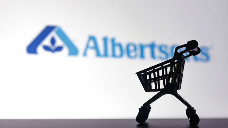Albertsons logo, with a miniature shopping cart in front of it