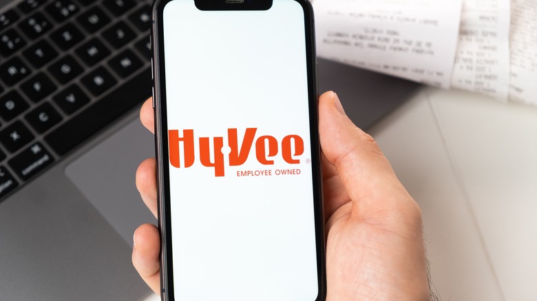 The Hy-Vee logo is displayed on a smartphone