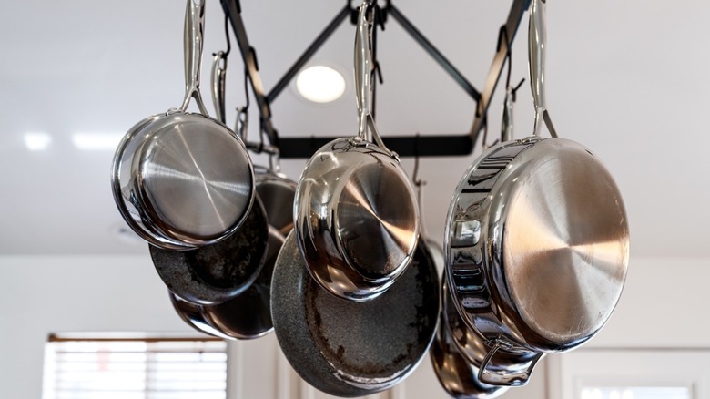 A rack of silver hanging pots