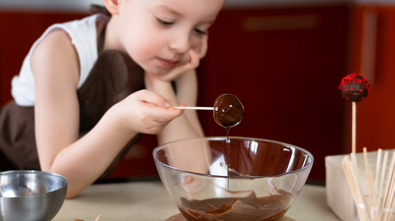 A child dipping cake pops