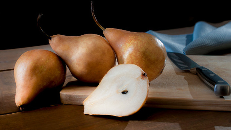 four pears on a cutting board
