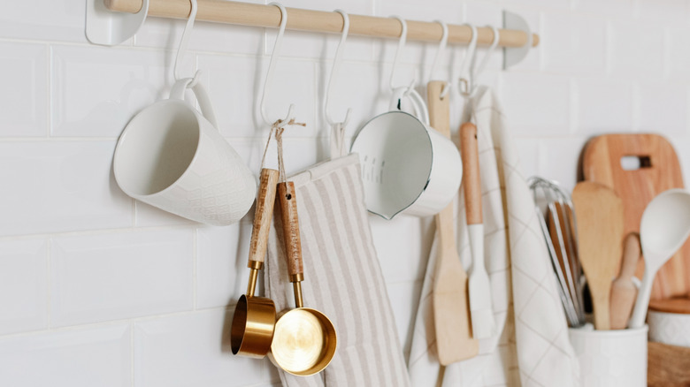 Measuring cups on a hanging rail in kitchen