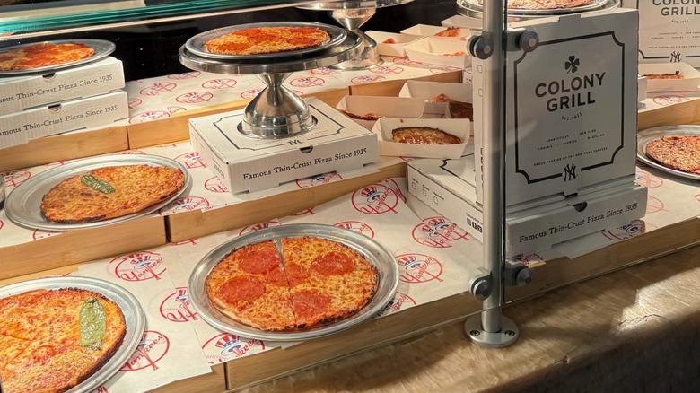 Window display of Colony Grill pizzas