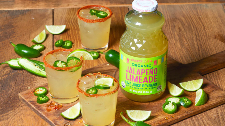 A jar of Organic Jalapeño Limeade next to margaritas and jalapeno