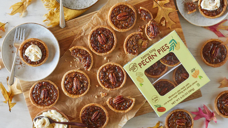 Board filled with Trader Joe's Teeny Tiny Pecan Pies next to a package of the pies