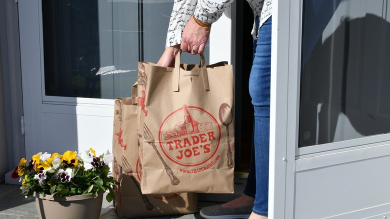 Woman carrying paper Trader Joe's bags