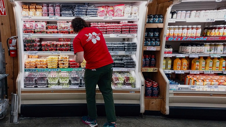 An employee restocks a fridge at a Trader Joe's