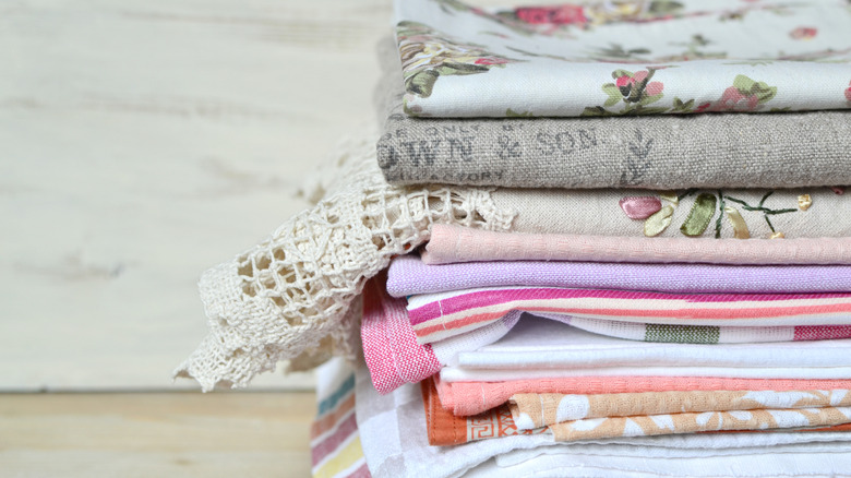Stack of vintage kitchen linens of various styles and materials