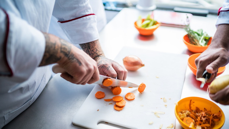 Hands cutting carrots