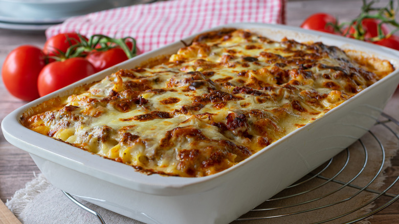 Pan of lasagna with crispy top and tomatoes