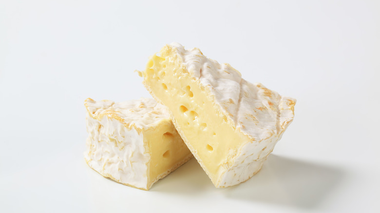 Two chunks of camembert cheese stacked on top of each other.