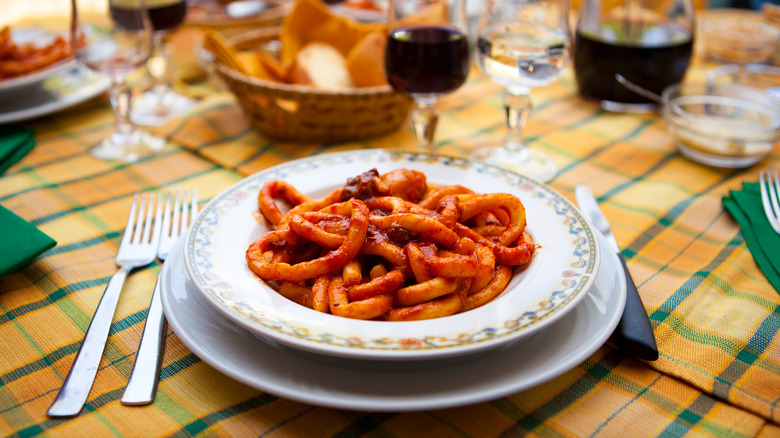 Pasta dish with red sauce on fully set table