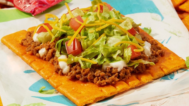 A Taco Bell Big Cheez-It Tostada with refried beans on a wrapper