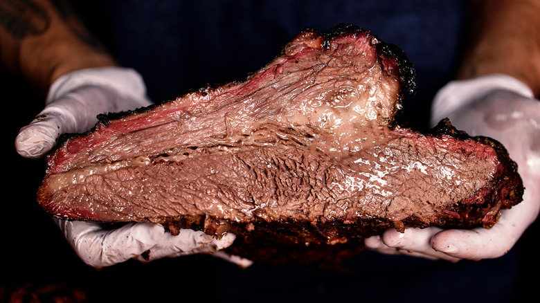 hands holding a brisket