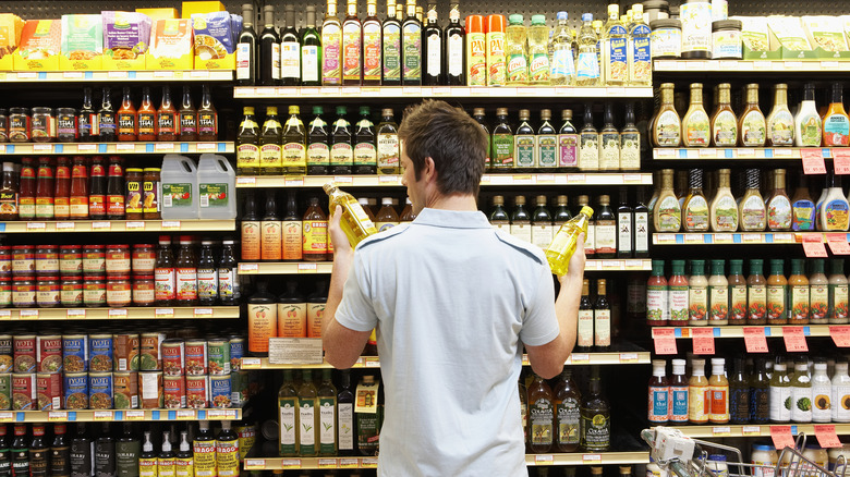 A shopper decides between two products in a grocery store aisle