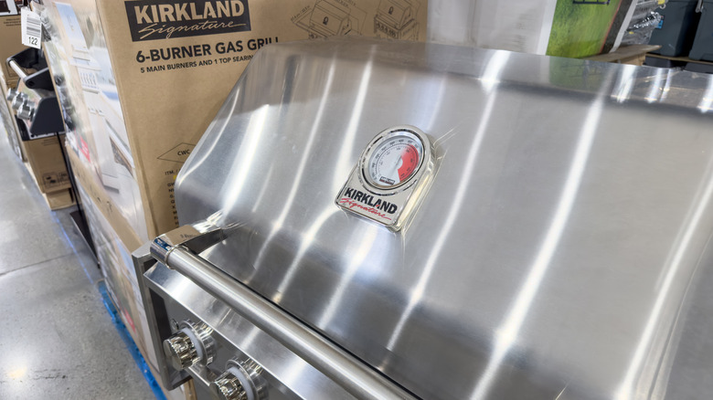 Man smiling while grilling with Kirkland gas grill