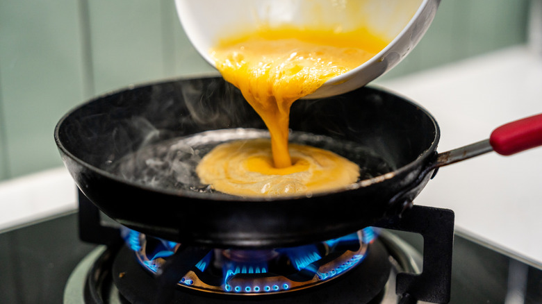 Eggs pouring into pan