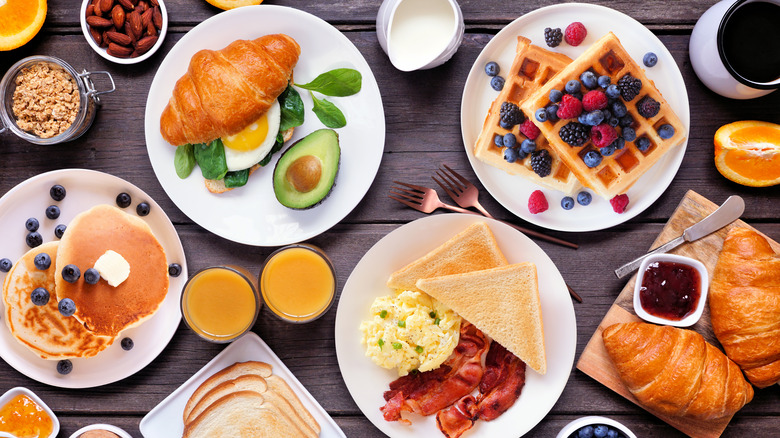 Breakfast dishes on table with various breakfast foods on them