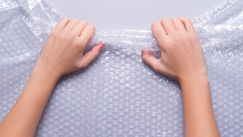 Hand pulling bubble wrap