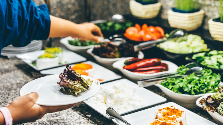 A person choosing food at a buffet.