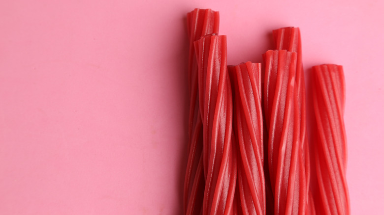 Red licorice against a pink background