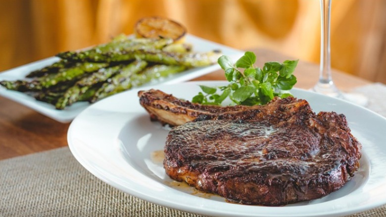 A Bone-In Ribeye in selective focus on a white plate at The Capital Grille