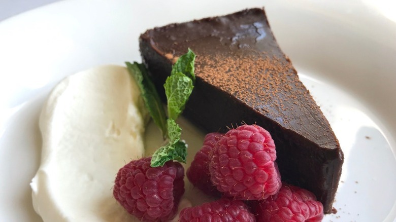 Close up of a flourless chocolate espresso cake with raspberries and cream at The Capital Grille