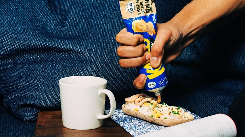 Kalles Kaviar being squeezed onto toast