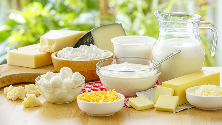 Various kinds of dairy products in bowls and containers on a wooden table