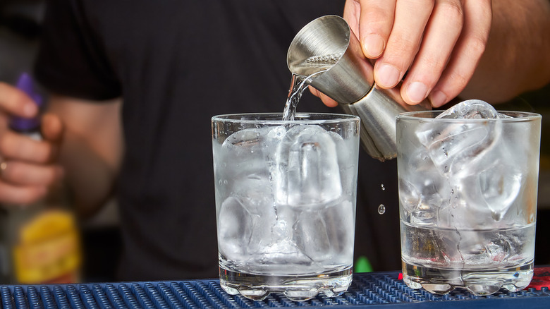 A person pouring gin