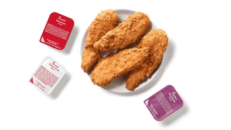 Chick-fil-A Chick-n-Strips with sauce packets on a white background