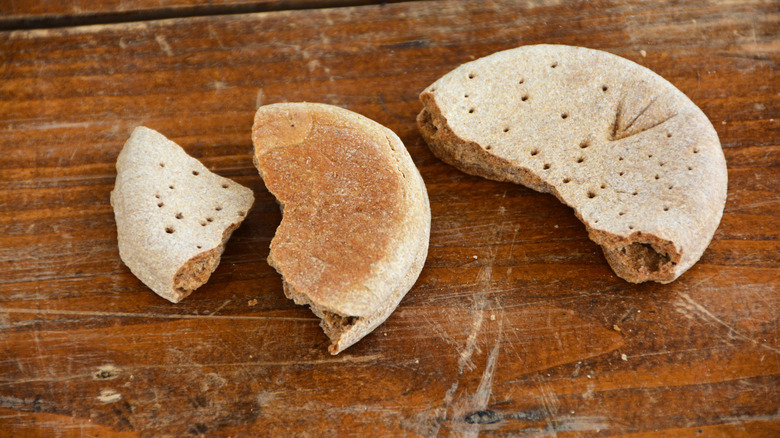 Pieces of hardtack are broken up on a table.