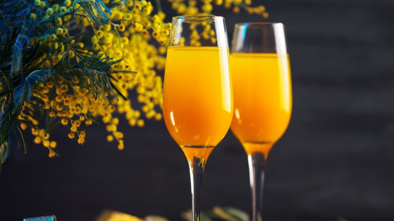 Two champagne flutes with mimosas