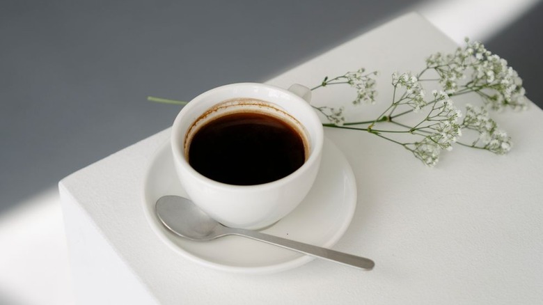 White mug with Americano on white table