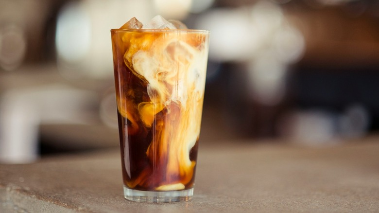 Iced shaken espresso in glass on wooden table