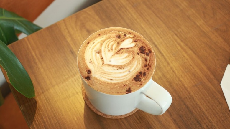 Hot mocha coffee drink in white mug on wood table