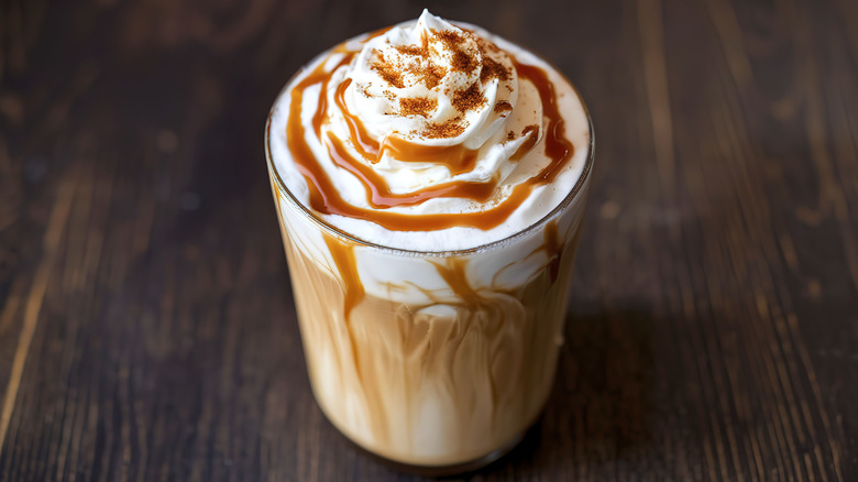 Iced caramel latte with whipped cream and drizzle