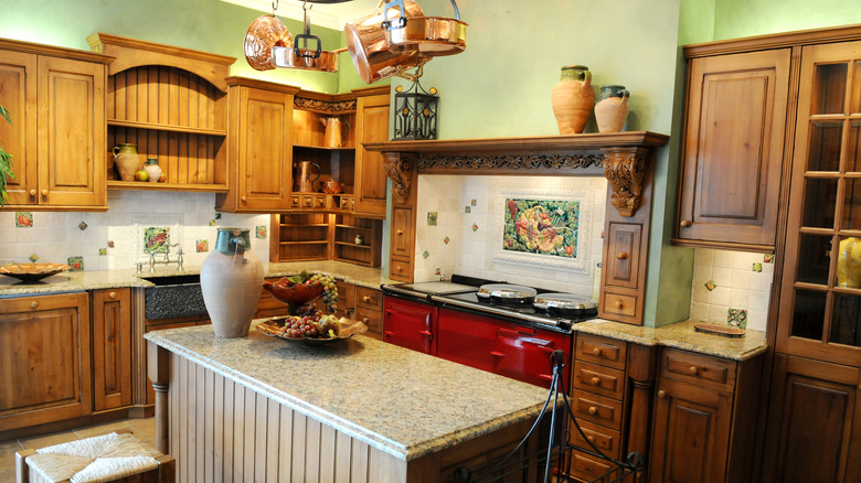 Kitchen with brown cabinets and light-colored marbled countertops with green walls