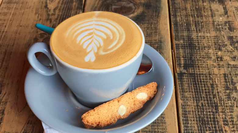cappuccino in blue saucer with biscotti
