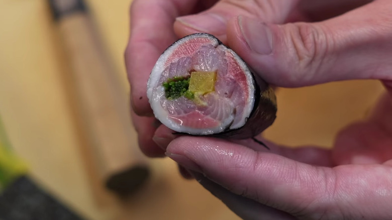 Hand holding one iwashi roll