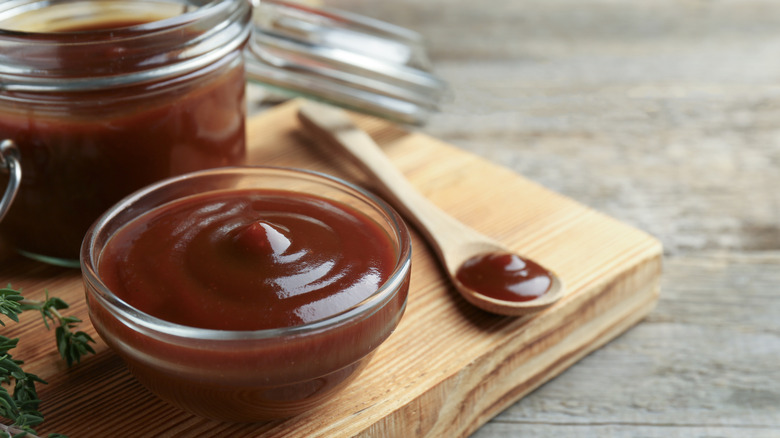 BBQ sauce in bowl on wooden board
