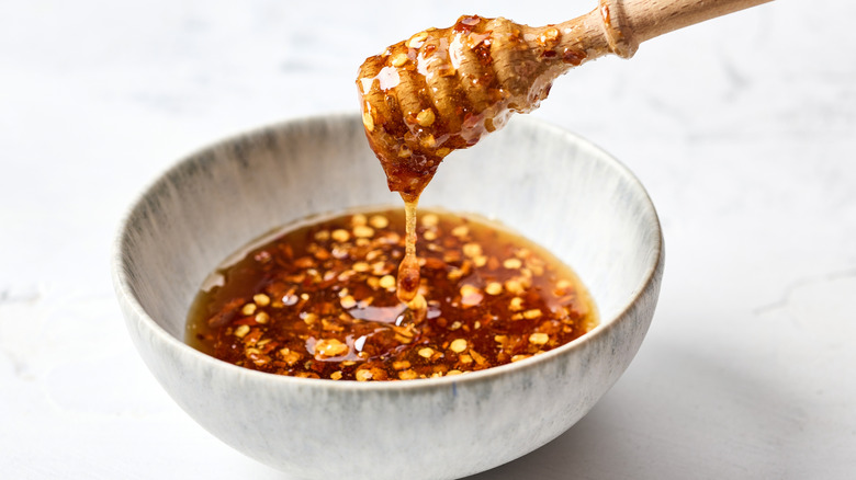 White bowl of honey infused with chili flakes
